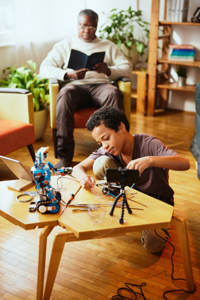一个受过良好教育的小男孩为视频博客录制自己的视频，并制作了一个机器人。电子和人工智能教育。图片下载