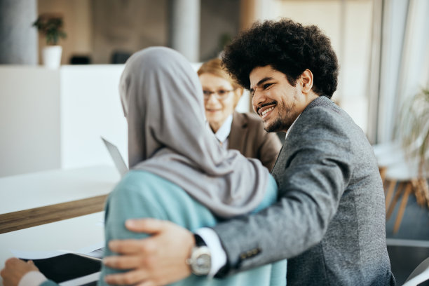 快乐的中东男人和他的妻子正在办公室与财务顾问协商。图片下载