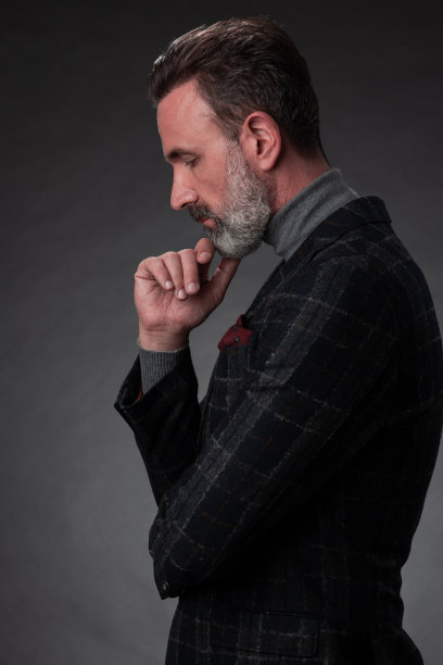 一名时尚优雅的老年商人的肖像，留着胡子和休闲的商务服装在摄影工作室孤立在黑暗的背景下手势图片下载