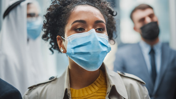 戴口罩的国际人士乘坐电梯前往商务中心图片下载
