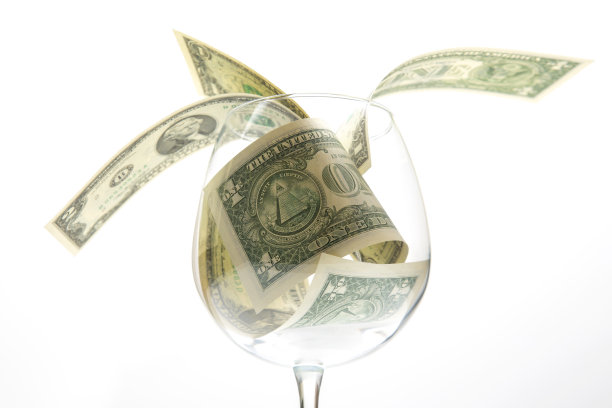 一张美元钞票躺在一个空酒杯里。葡萄酒行业的业务。酒精营销图片下载