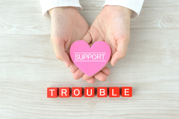 人的手用心形物体，木块用“麻烦”字图片下载