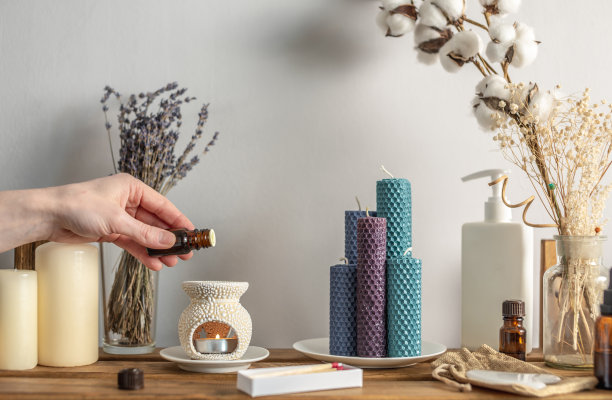 女性手拿一瓶精油，滴在香薰灯里进行芳香疗法，平静放松的氛围，专注于冥想、护理程序等仪式图片下载