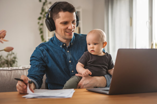 年轻的父亲在家工作图片下载