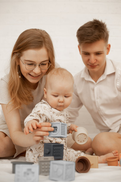 幸福鼓舞的家庭妇女戴眼镜，男人，婴儿玩游戏的垂直照片。创造力和想象力。图片下载