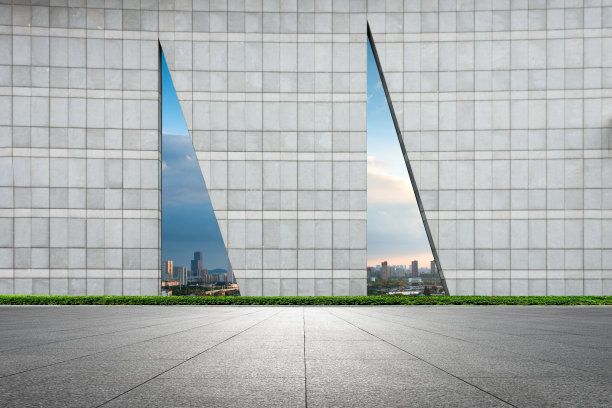 在晴空万里的天空下，城市中心的建筑物后面是石砌的广场图片下载