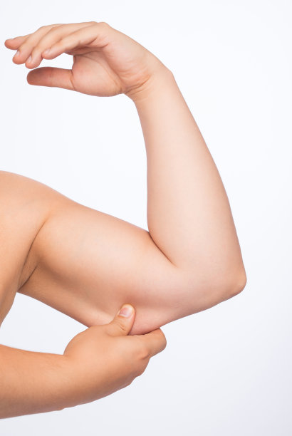 一个男人手臂上的脂肪，减肥的概念和健康的生活方式。图片下载