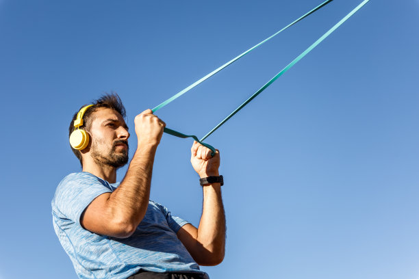 白人男子训练与弹性胶带户外蓝天背景图片下载