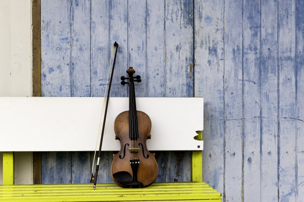小提琴和中提琴放在黄色的木凳上，练习期间休息时间为音乐会做准备。图片下载