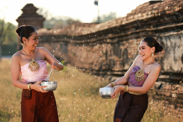 两名亚洲女子穿着泰国传统服饰一起泼水，宋干节的文化生活方式，泰国新年的文化和生活方式图片下载