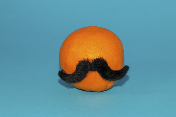 橙色，蓝色背景上的小胡子，时尚食品嬉皮士的创意概念图片下载