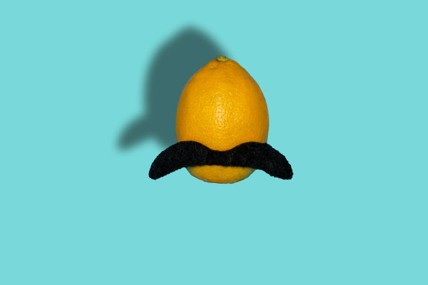创意时尚柠檬与胡子在一个柔和的蓝色背景，创意概念时尚食品，柠檬在空气中图片下载