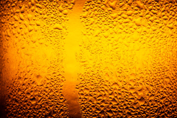 宏观的啤酒瓶纹理，水滴在啤酒瓶上的纹理，水滴在啤酒杯上关闭了啤酒的场景。图片下载