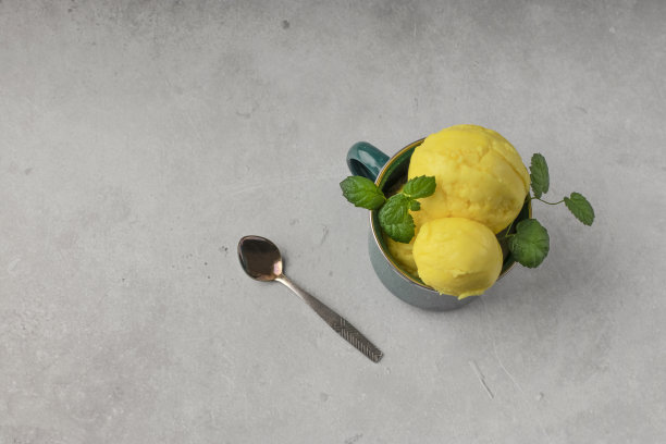 芒果球冰淇淋配新鲜薄荷，金属杯，淡色背景。自然自制的食物。前视图。副本的空间。图片下载
