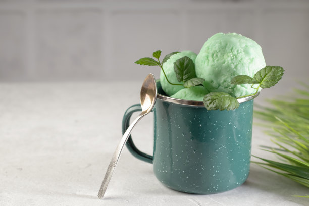 有机冰淇淋，新鲜的绿色薄荷，金属杯，浅色背景。健康的天然食品。本空间图片下载