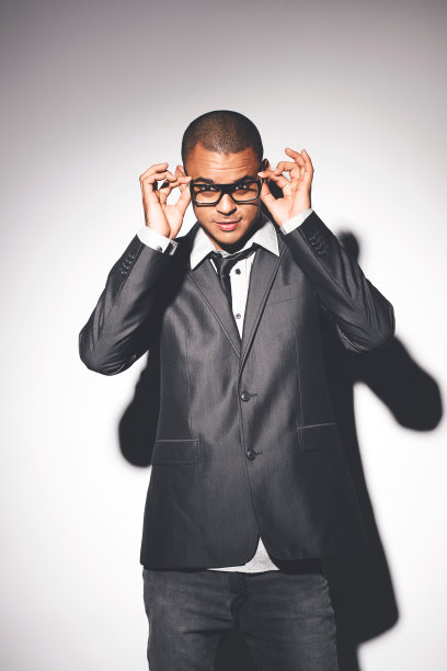 裁剪的肖像英俊的年轻男子摆姿势在工作室的灰色背景图片下载