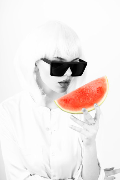 戴白色假发的女人手里拿着一片红色的西瓜图片下载