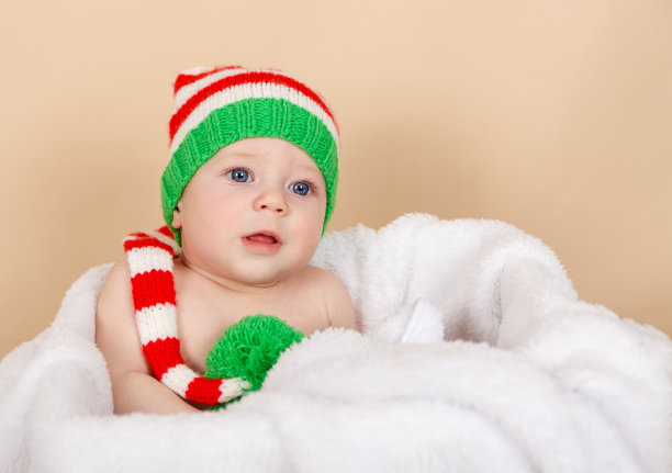 戴红帽子微笑的婴儿。孩子们享受节日。圣诞快乐图片下载