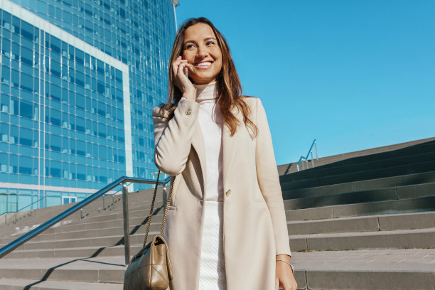 年轻迷人的女商人在户外用手机交谈图片下载