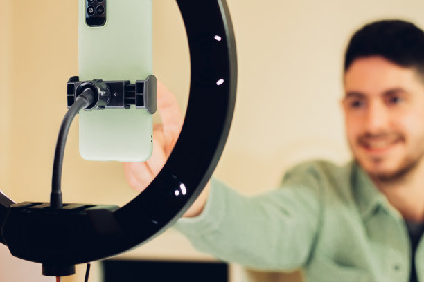 视频日志的录制设备。特写的手机录制视频的内容创作者在背景。图片下载