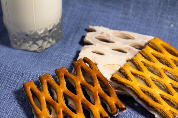 一杯牛奶的照片与开放的松饼饼干白巧克力在蓝色的背景-特写图片下载