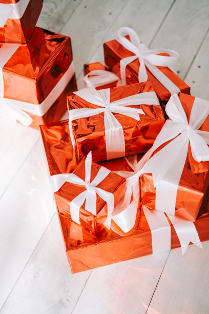 一组红色的礼品盒和白色的丝带在地板上。图片下载