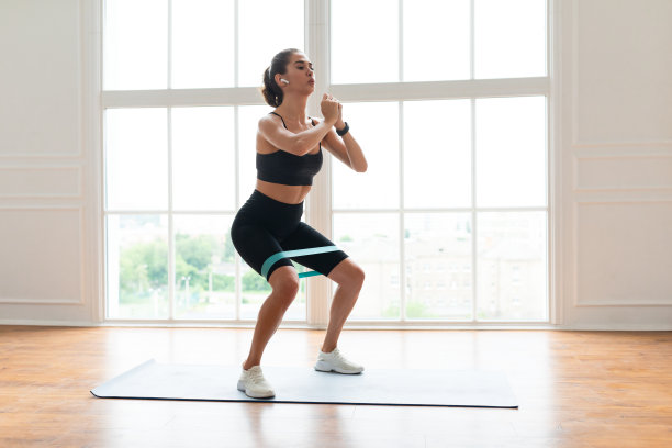 穿着黑色运动服的女人用橡皮筋锻炼图片下载