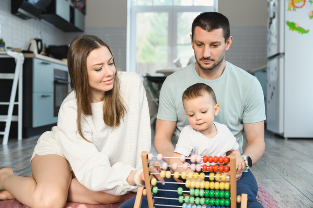 爸爸妈妈教孩子用算盘算数。这孩子在学数学。图片下载
