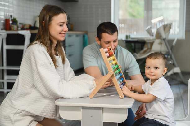 爸爸妈妈教孩子用算盘算数。这孩子在学数学。图片下载