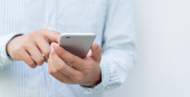 近距离拍摄亚洲男子使用智能手机移动设备玩或在线购物或查看时间和日期的生活理念图片下载