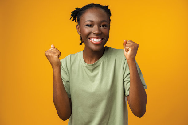 快乐的非裔美国女人看起来很惊讶在黄色工作室图片下载