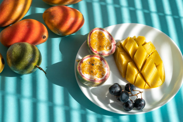 盘子里的水果片:芒果、百香果和葡萄图片下载