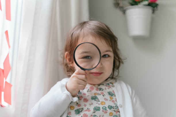 女学生在用放大镜看东西。回到学校的概念。图片下载