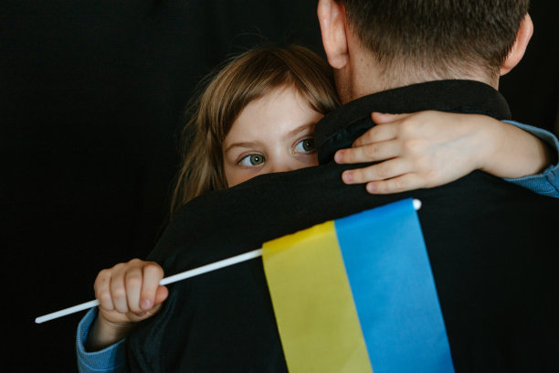 拿着乌克兰国旗的小女孩抱着她爸爸图片下载