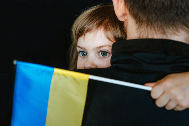拿着乌克兰国旗的小女孩抱着她爸爸图片下载