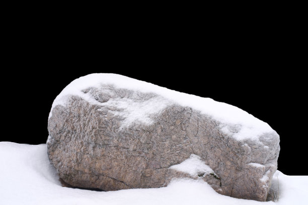 自然的石头在雪孤立在黑色的背景上图片下载