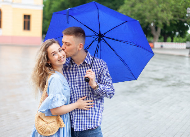在这座城市的雨天里，一对可爱的情侣在伞下相爱图片下载