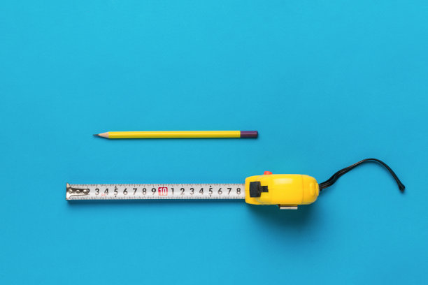 展开的卷尺和铅笔在蓝色的背景上。平的。图片下载