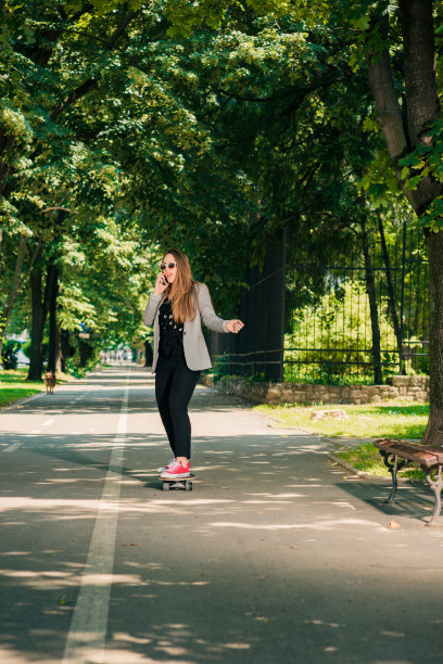 滑板上的小女孩滑过公园图片下载