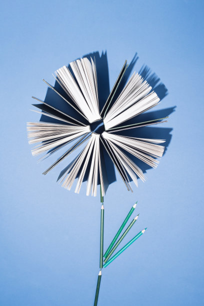 旧书和铅笔在亮蓝色的背景上。教育、知识或自然概念。平的。图片下载