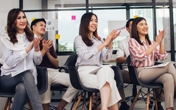 一群人穿着休闲的商务衬衫，参加研讨会和研讨会，鼓掌，笑得很开心。图片下载