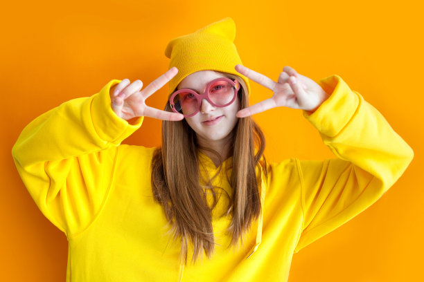 年轻漂亮的时髦女人的肖像，戴着黄色的帽子和眼镜。图片下载