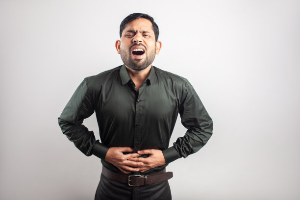 有胃痛症状的年轻亚洲男子图片下载