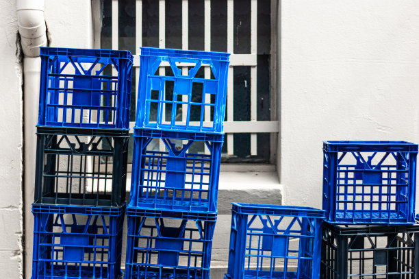 牛奶箱堆放在商店后面的墙前和窗户前图片下载