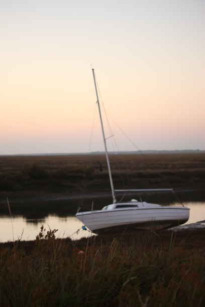 秋天，英国诺福克郡布莱克尼外的潮汐沼泽上的夕阳图片下载