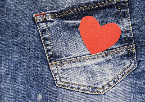 牛仔裤口袋特写照片背景上的两颗心。情人节背景音乐。图片下载
