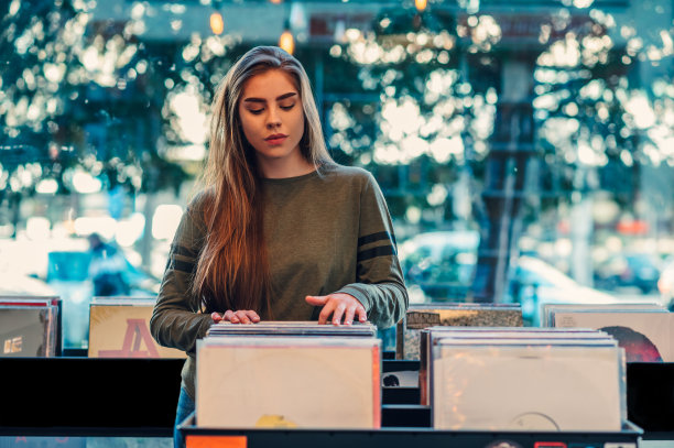 在唱片店里挑选黑胶唱片的女人图片下载