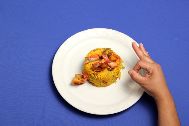 海鲜饭是西班牙巴伦西亚市的一种传统美食，用白色盘子盛着藏红花、海鲜、虾和蔬菜图片下载