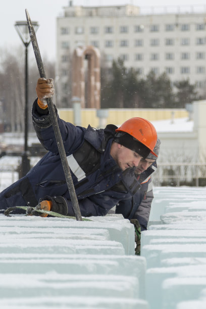 一名装配工人正试图用撬棍把这些冰块撬开图片下载