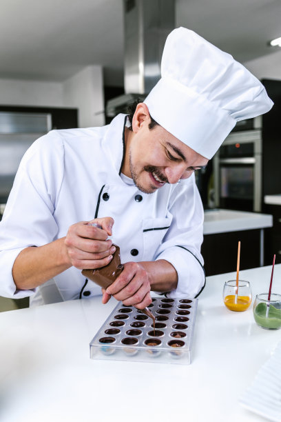 拉丁男子糕点厨师穿着制服在墨西哥拉丁美洲的厨房准备美味的甜点巧克力图片下载